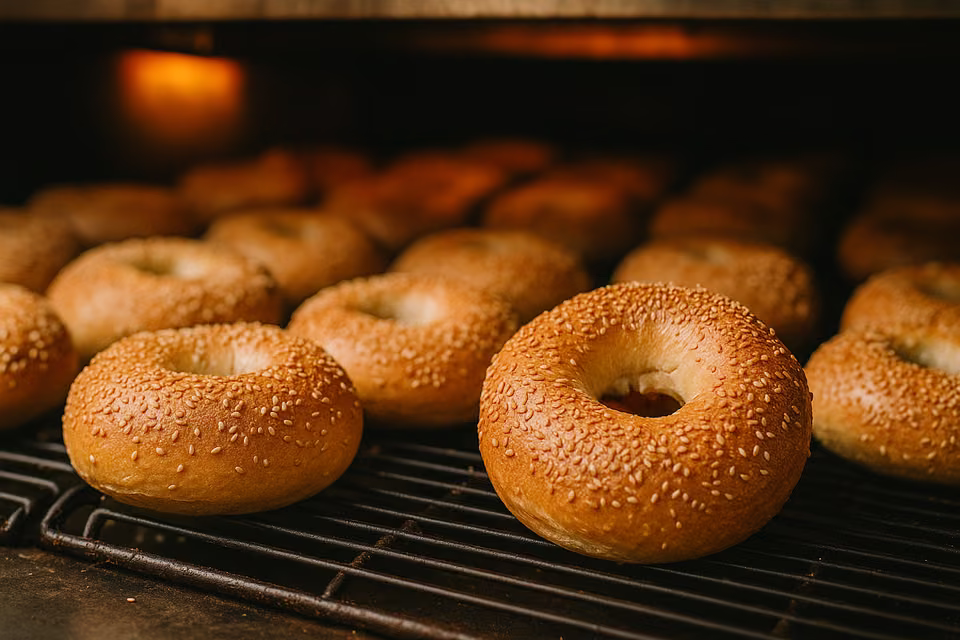 Golden sesame bagels on a baking rack